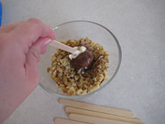 dipping ice cream into nuts