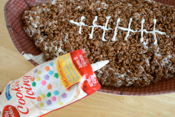 Add Frosting to a Giant Rice Crispy Football for the White String