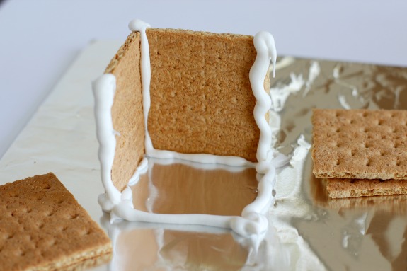 Adding frosting to graham crackers for candy houses
