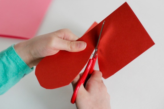 Cutting Paper Hearts @makeandtakes.com