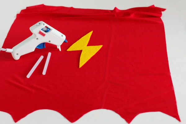 Gluing on the lightning bolt for a superhero kids cape