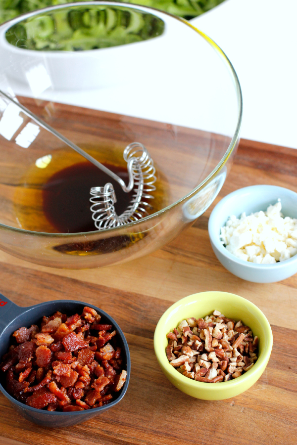 Mixing Arugula Salad with Bacon, Feta, and Pecans