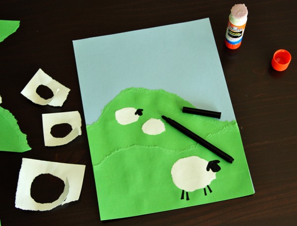 Torn paper sheep on a hill