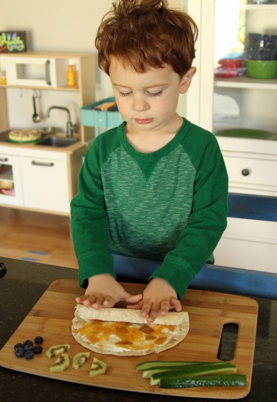 Rolling a cream cheese and jelly tortilla