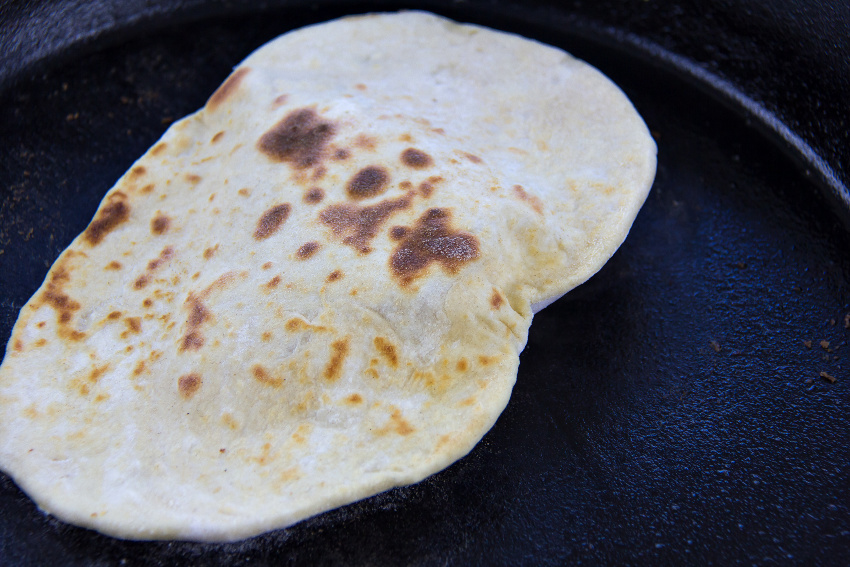 flatbread being cooked in a cast-iron skillet