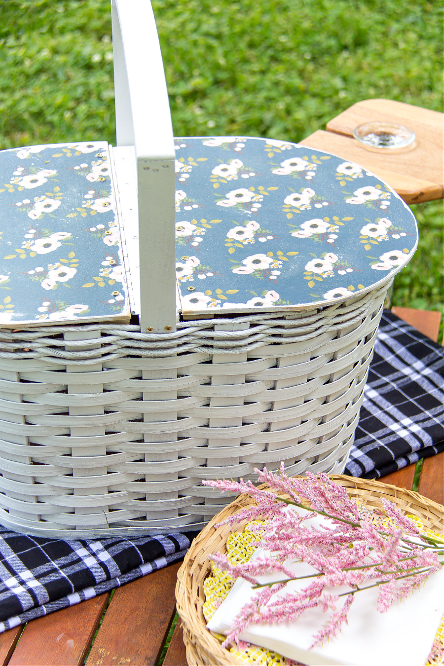 a white picnic basket with a handmade blue floral lid