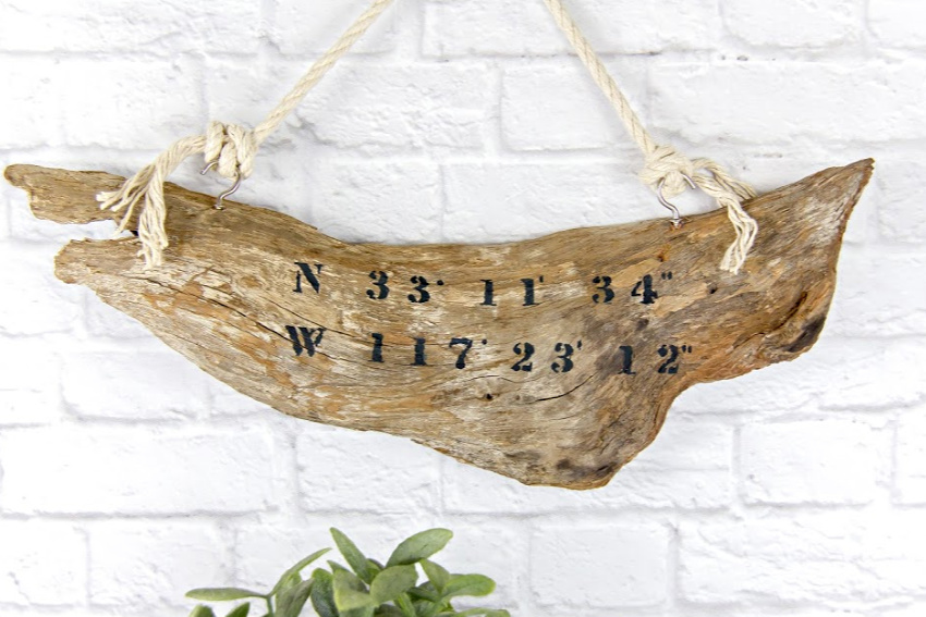driftwood sign with co-ordinates stenciled onto it