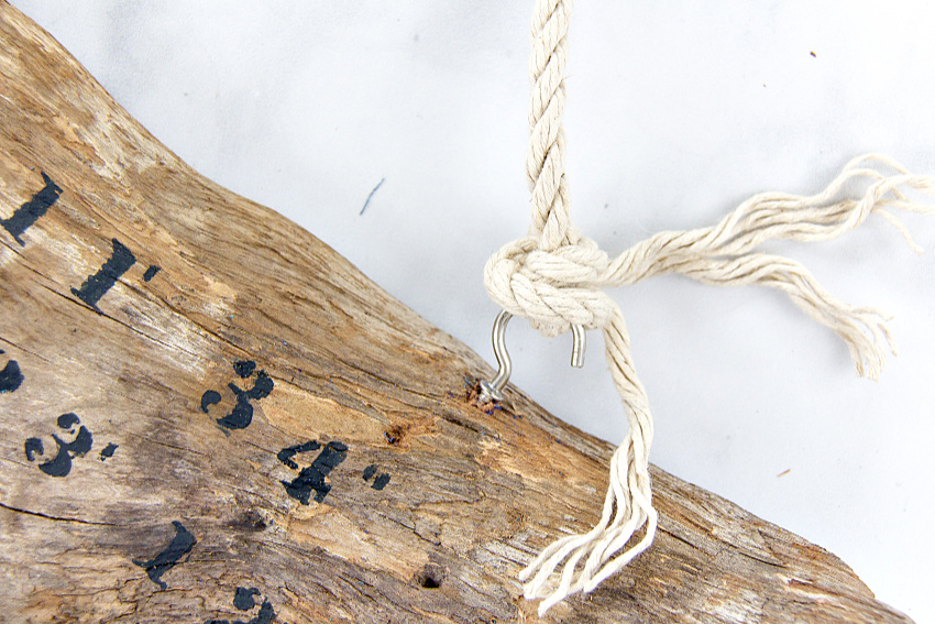 rope being attached to hooks on driftwood