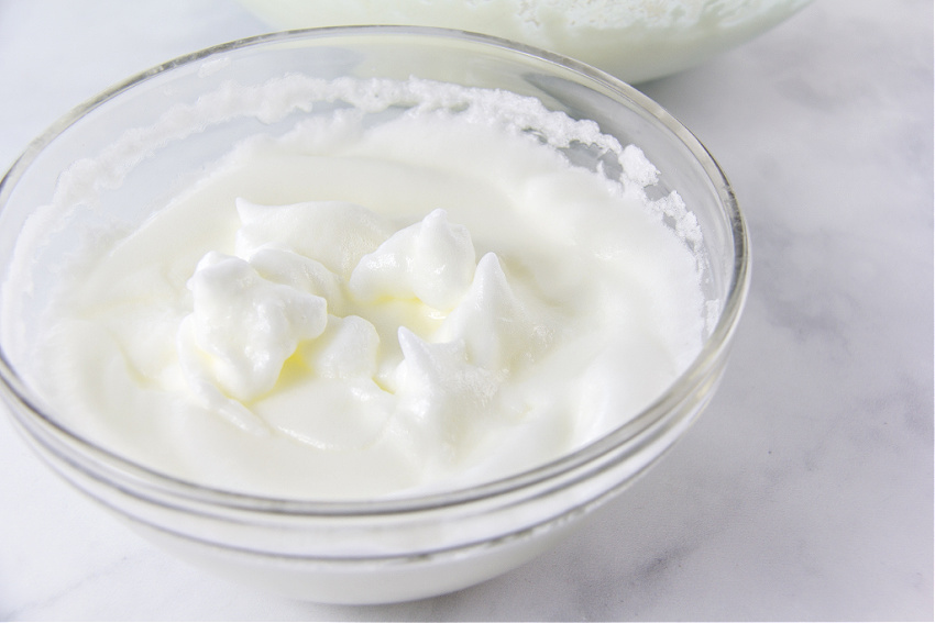 a glass bowl with egg whites beaten into stiff peaks