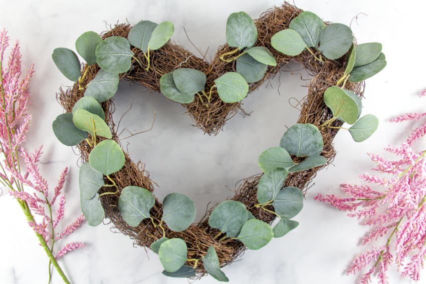 a natural vine wreath with green leafy stems