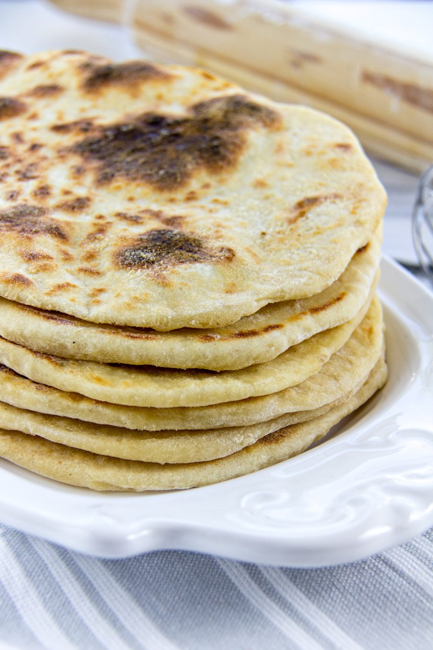 homemade flatbread stacked on a white plate