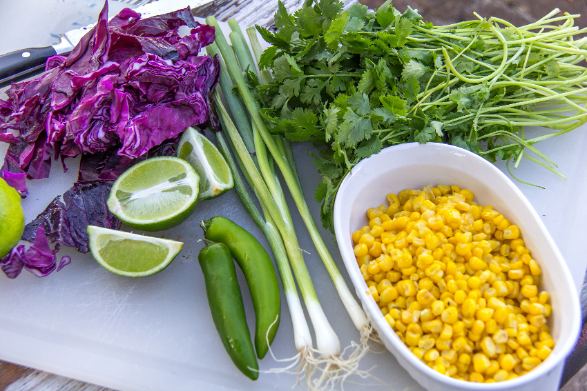 corn, green onions, red cabbage, and other fresh produce to make taco slaw
