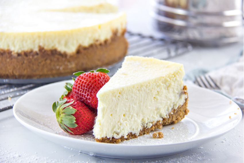 a slice of gluten free cheese with fresh strawberries on a white plate