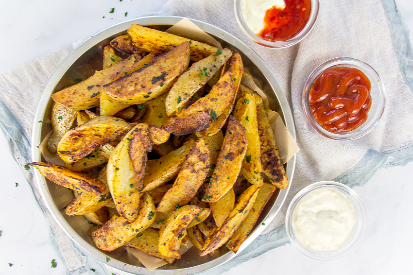 homemade seasoned potato wedges with condiments