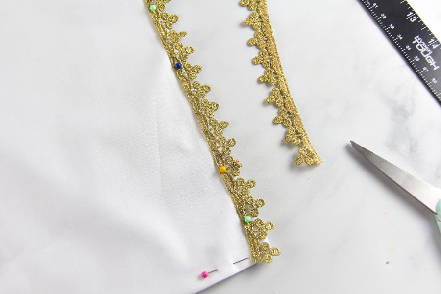 gold trim being added to a handmade white table runner