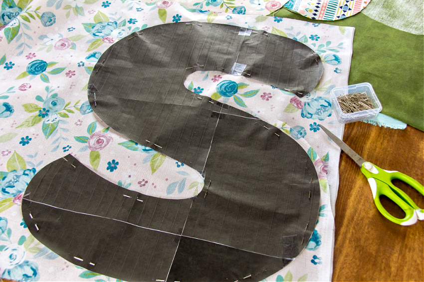 a large paper letter s pinned to fabric