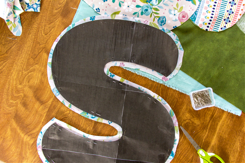 a letter s cut out of fabric using a paper template