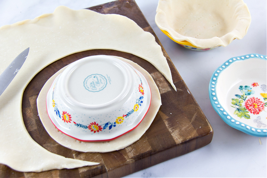 mini pie dishes on top of pie crust to measure size