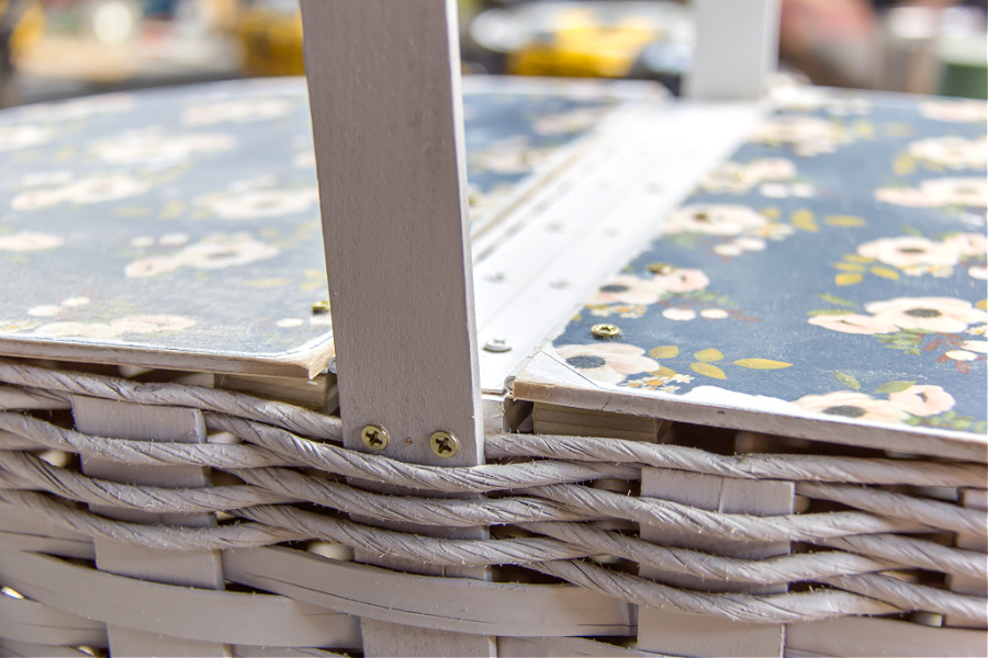 A wood lid being attached to a basket to turn it into a picnic basket