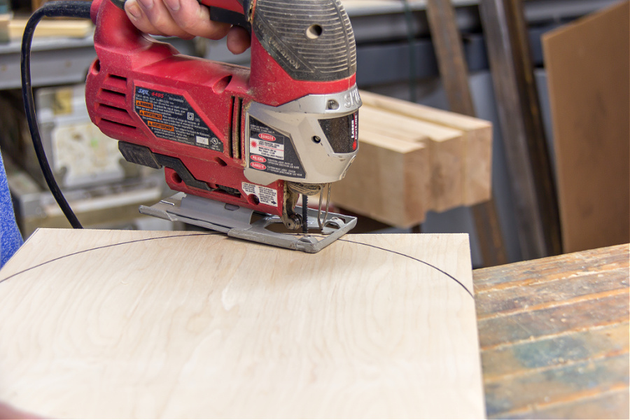 a piece of wood being cut with a saw to make a lid for a picnic basket