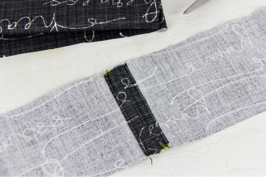 fabric being sewn together to make a shoulder strap for a bag