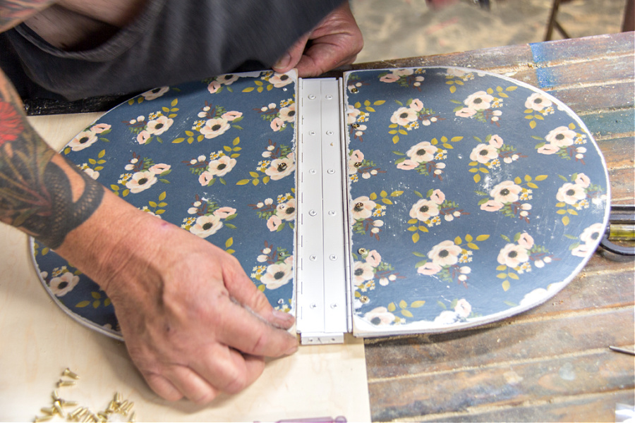 A lid for a picnic basket being assembled using wood and hinges