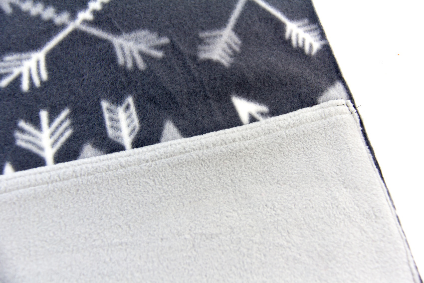 a grey pocket being sewn onto a dark grey pillow cover