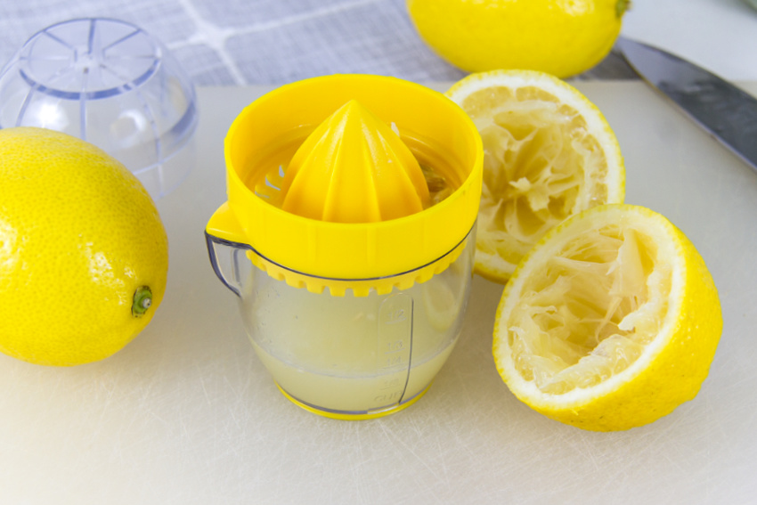 lemons being squeezed using a lemon juicer