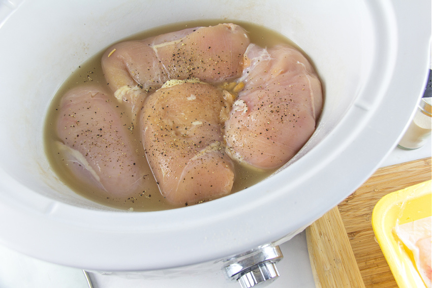 chicken breasts and broth in a slow cooker