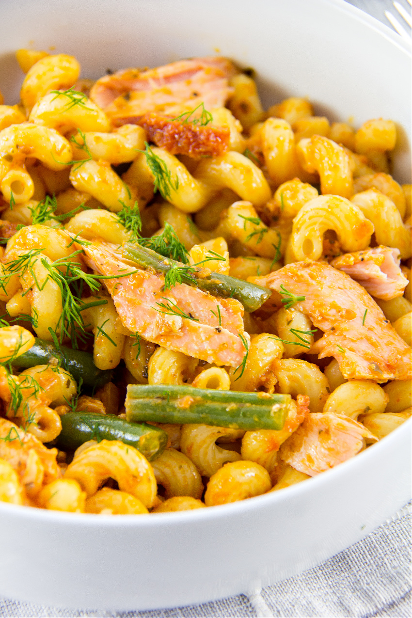 cellentani pasta with salmon and green beans in a white bowl