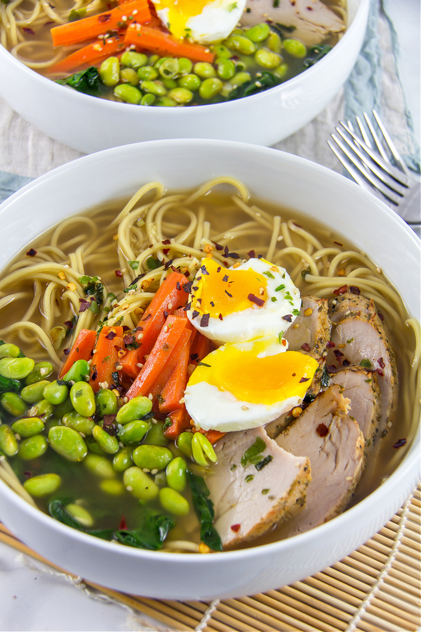 pork ramen in a white bowl topped with egg