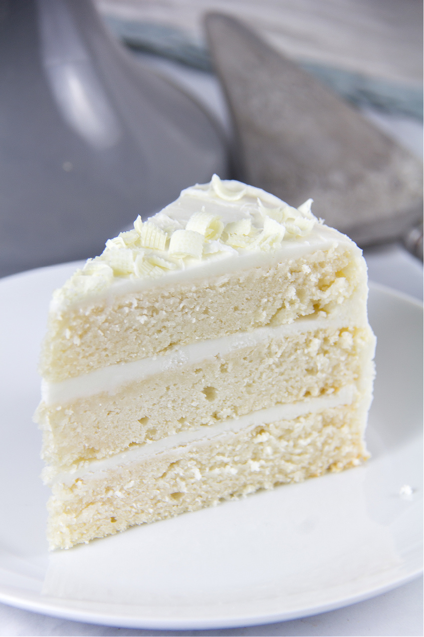 a slice of white cake with white frosting