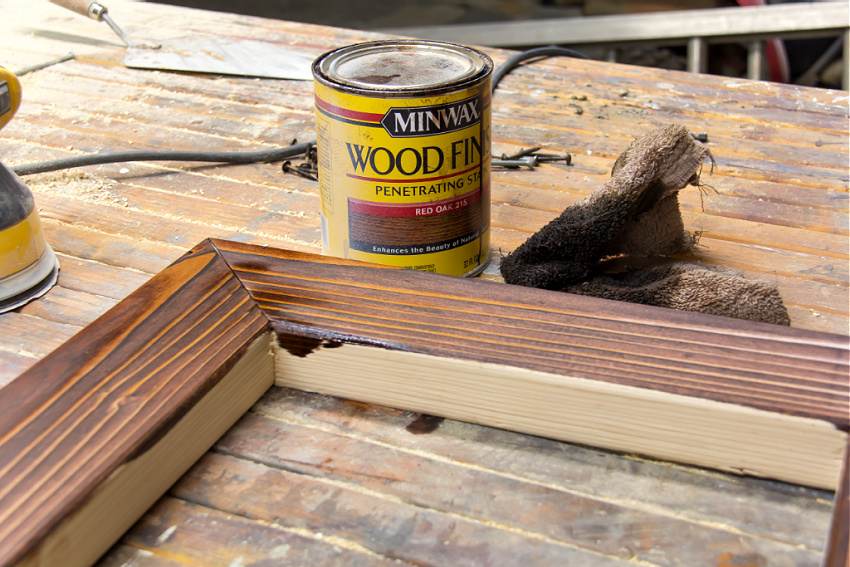 a pine board frame being stained with red oak