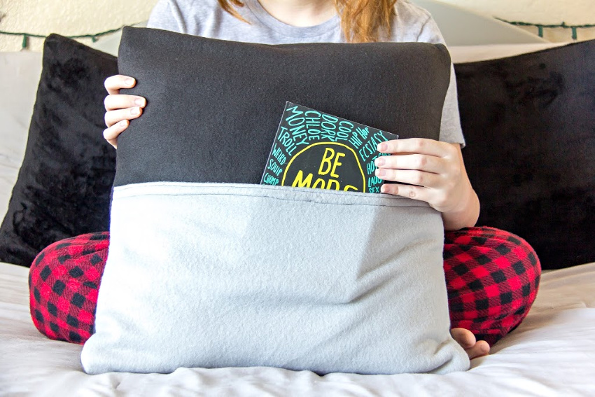 a teen girl holding a handmade book pillow